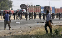 Police officers chase supporters of Tehreek-e-Labiak Pakistan, a radical Islamist party, during their protest march toward Islamabad, on a highway in the town of Sadhuke, in eastern Pakistan, Wednesday, Oct. 27, 2021. Violence at the anti-France Islamist rally in Sadhuke left at least one police officer and two demonstrators dead. ​They demanded the expulsion of France's envoy to Pakistan over publication of caricatures of Islam's Prophet Muhammad in France. (AP Photo/K.M. Chaudary)