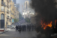 People clash with police during a protest against the political elites and the government after this week's deadly explosion at Beirut port which devastated large parts of the capital and killed more than 150 people, in Beirut, Lebanon, Saturday, Aug. 8, 2020. (AP Photo/Hassan Ammar)