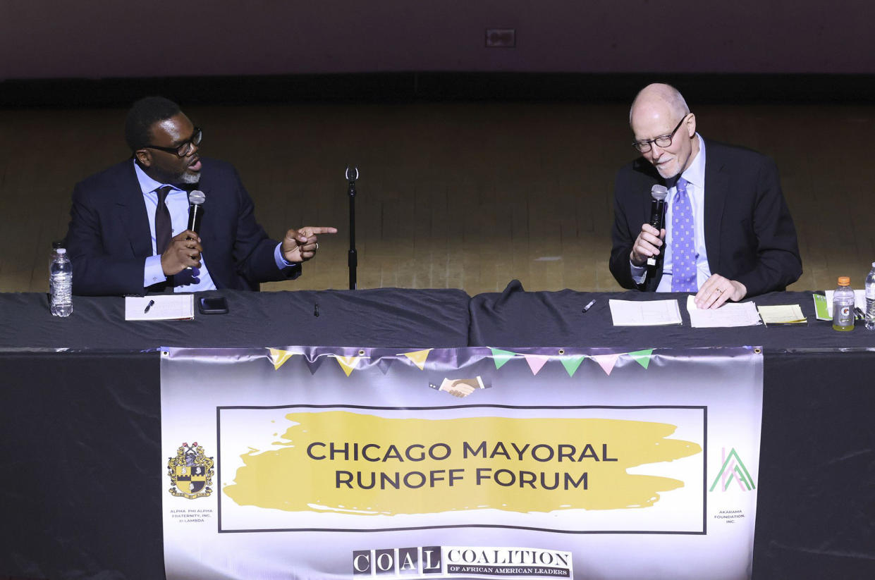 Johnson, at the microphone onstage, points an accusing finger at Vallas, above a banner saying: Chicago Mayoral Runoff Forum and COAL, Coalition of African American Leaders.