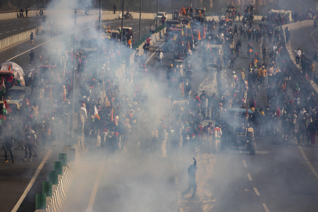 Protesting farmers are seen amid tear gas smoke fired by police in an attempt to stop them from marching to the capital during India's Republic Day celebrations in New Delhi, India, January 26, 2021.  / Credit: Altaf Qadri/AP