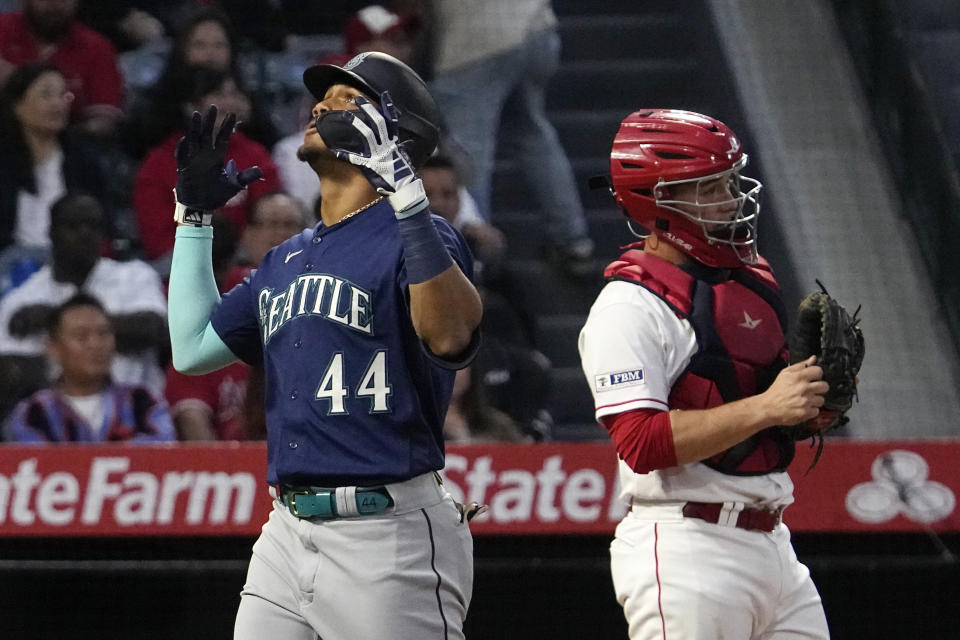 Seattle Mariners' Julio Rodriguez, left, celebrates after hitting a two-run home run as Los Angeles Angels catcher Matt Thaiss stands at the plate during the third inning of a baseball game Saturday, June 10, 2023, in Anaheim, Calif. (AP Photo/Mark J. Terrill)
