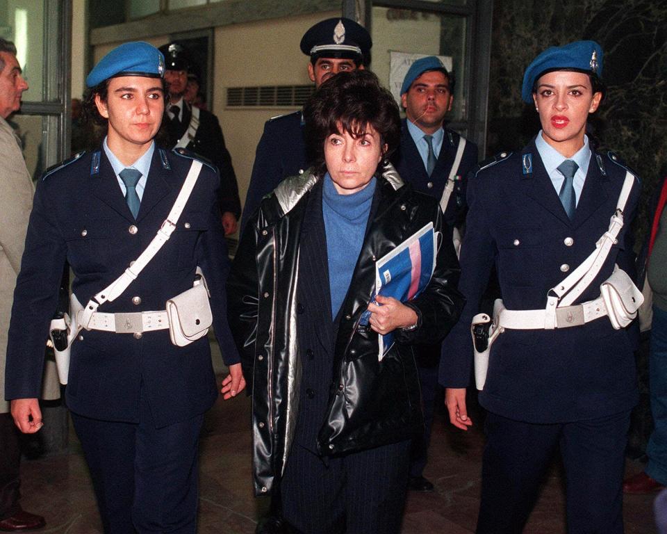 Maurizio Gucci's ex-wife Patrizia Reggiani is escorted by police officers into Milan's court in this November 3, 1998 photo. (AP Photo/Luca Bruno)