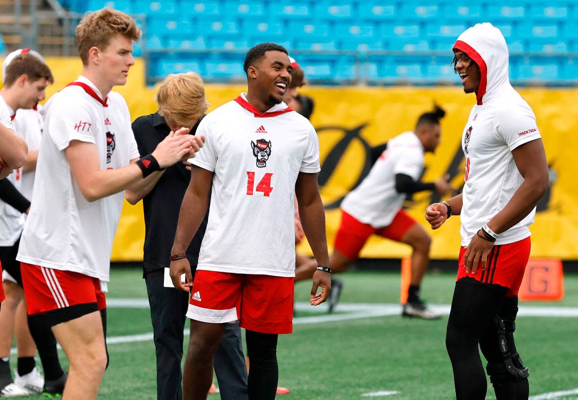 N.C. State quarterback Jack Chambers (14), center, laighs with quarterback MJ Morris (16) as they warm up with quarterback Ben Finley (10) before the Wolfpack’s game against Maryland in the Duke’s Mayo Bowl at Bank of America Stadium in Charlotte, N.C., Friday, Dec. 30, 2022.