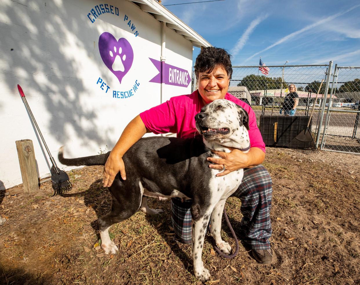 Stefanie Badillo, owner of Crossed Paws Pet Rescue, with one of her rescue dogs at the shelter in Winter Haven. ERNST PETERS/ THE LEDGER