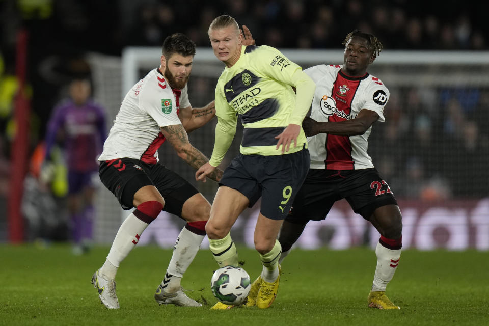 Manchester City's Erling Haaland, center, battles for the ball with Southampton defenders during the English League Cup quarter final soccer match between Southampton and Manchester City at St Mary's stadium in Southampton, England, Wednesday, Jan. 11, 2023. (AP Photo/Alastair Grant)