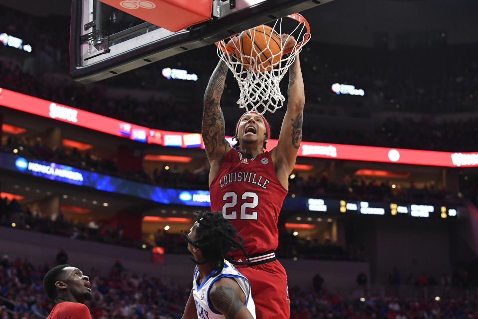 Louisville guard Tre White (22) scores over Kentucky guard Rob Dillingham during the second half of an NCAA college basketball game in Louisville, Ky., Thursday, Dec. 21, 2023. Kentucky won 95-76. (AP Photo/Timothy D. Easley)