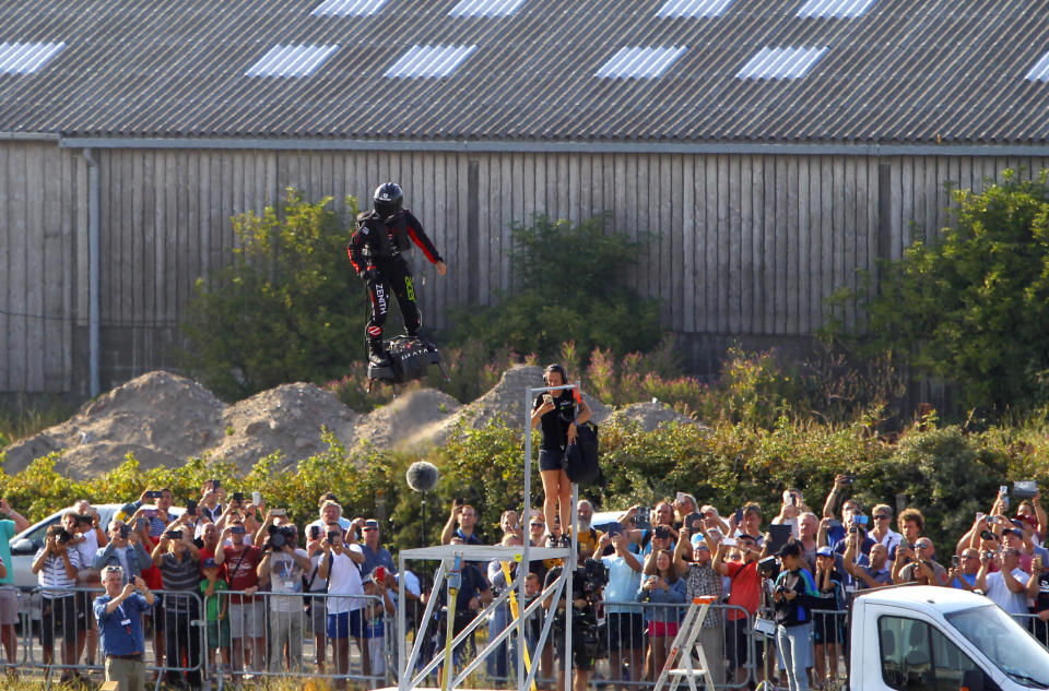 Onlookers observe the take-off as Franky Zapata, a 40-year-old inventor, lifts off in Sangatte, Northern France, at the start of his attempt to cross the channel from France to England, aboard his flyboard, Thursday July 25, 2019. Zapata is anchored to his flyboard, a small flying platform he invented, taking off from Sangatte, in France's Pas de Calais region, and flying to the Dover area in southeast England. (AP Photo/Michel Spingler)