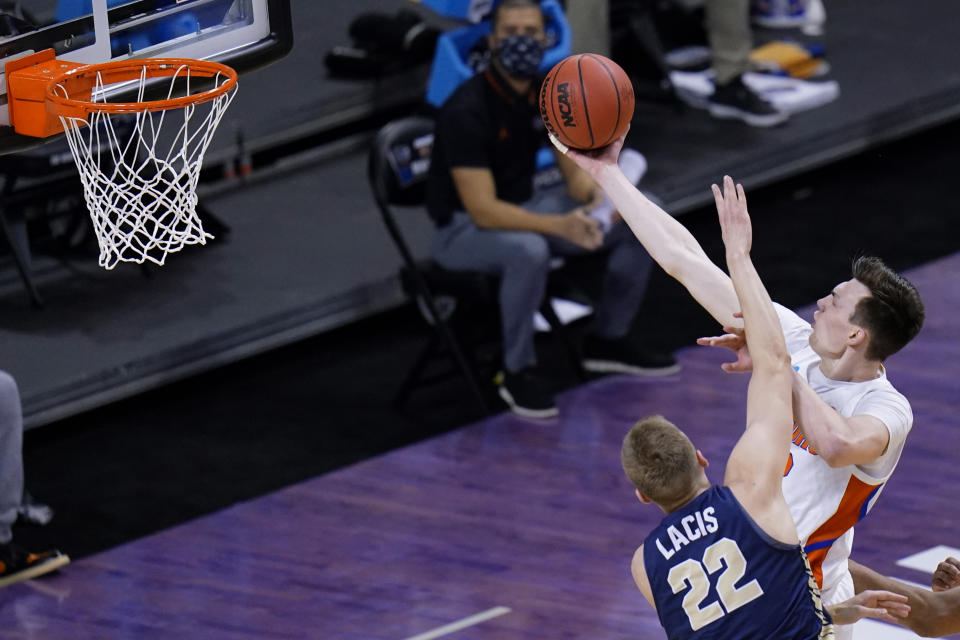 Florida forward Colin Castleton drives to the basket over Oral Roberts forward Francis Lacis (22) during the second half of a college basketball game in the second round of the NCAA tournament at Indiana Farmers Coliseum, Sunday, March 21, 2021 in Indianapolis. (AP Photo/AJ Mast)