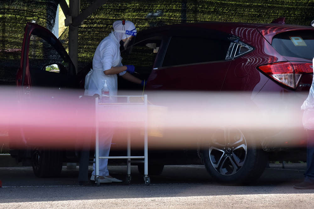 Health officers giving recipients the second dose of Pfizer-BioNTech type Covid-19 vaccine at Universiti Malaysia Sabah Labuan International Campus’ drive through vaccination centre, July 27, 2021. — Bernama pic