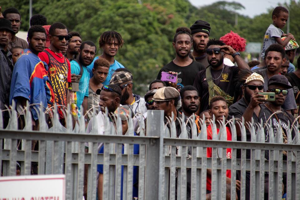 This picture taken on March 14, 2021 shows a crowd of people - none wearing face masks, nor social distancing - gathered outside the airport in Port Moresby to bid farewell to the casket of PNG's first prime minister Michael Somare, who died late February. Source: Getty