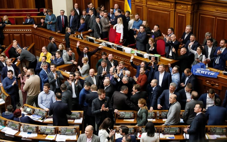 Ukrainian lawmakers react during a discussion of the law to remove a ban on the sale of farmland, at the parliament building in Kiev