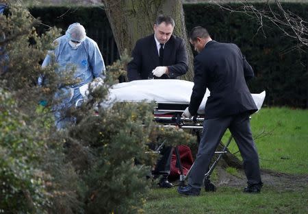 A forensic police officer and undertakers strap a body to a gurney near the grounds of Kensington Palace in London, Britain February 9 2016. REUTERS/Neil Hall