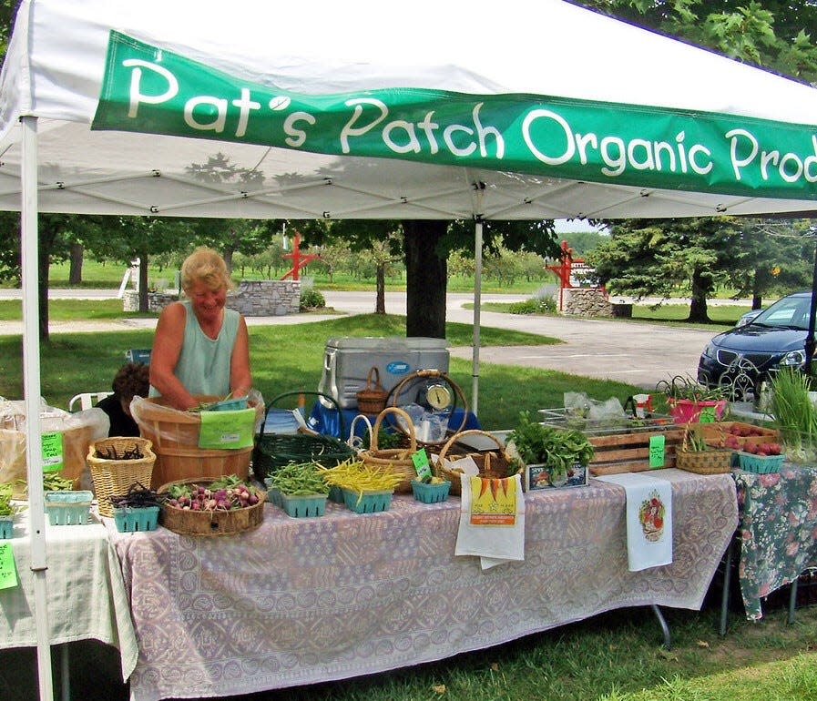 Pat Thorp of Pat's Patch Organic Produce in Fish Creek works at her regular stand at the farmers market held Wednesdays during the summer and fall on the grounds of the Settlement Shops in Fish Creek.