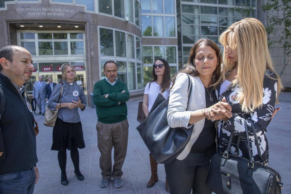 Two women embrace outside of a courthouse.