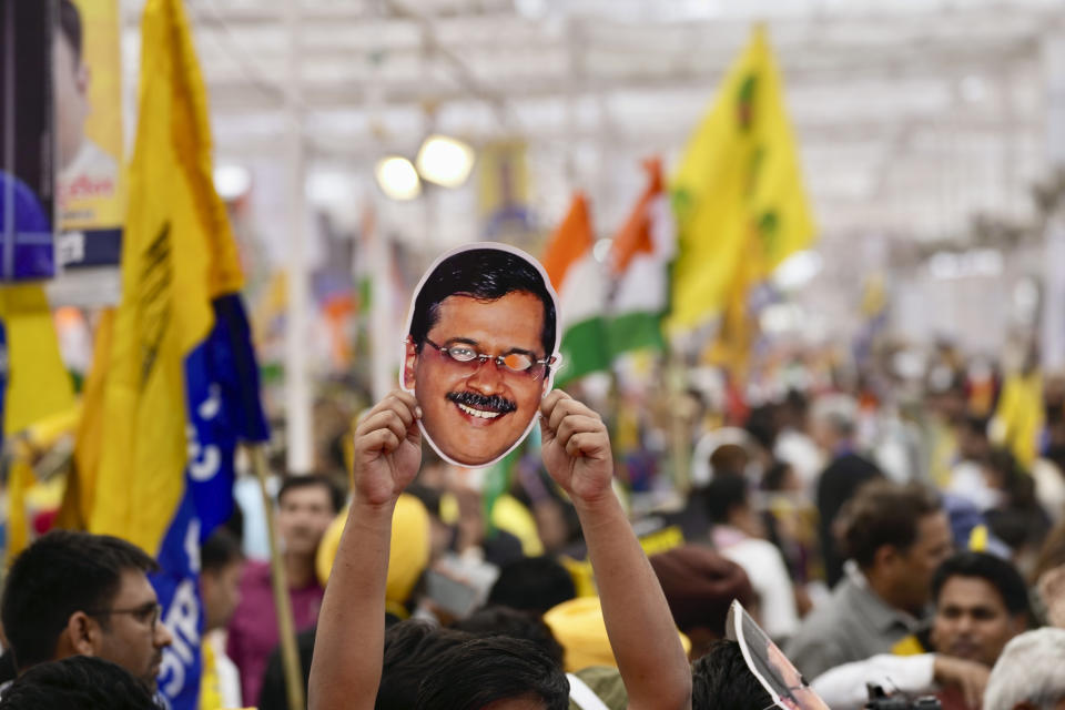 A supporter of the Aam Admi Party holds a mask in the likeness of the party leader and Delhi Chief Minister Arvind Kejriwal at a protest rally organized by INDIA bloc, a group formed by opposition parties, in New Delhi, India, Sunday, March 31, 2024. Protesters are demanding the release of the top elected official of New Delhi who was arrested on March 21 in a liquor bribery case. (AP Photo/Manish Swarup)