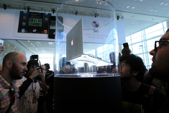 WWDC attendees look at the new MacBook Pro that is displayed following the keynote address at the Apple 2012 World Wide Developers Conference (WWDC) at Moscone West on June 11, 2012 in San Francisco, California. Apple unveiled a slew of new hardware and software updates at the company's annual developer conference which runs through June 15. (Photo by Justin Sullivan/Getty Images)