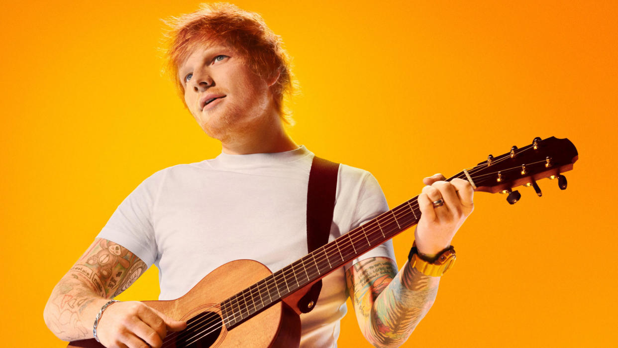  Ed Sheeran holding a guitar on an orange background 