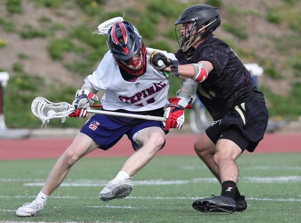 From left, Stepinac's Brady Sharkey (11) tries to get around Iona's Blaise New (11) during lacrosse action at Stepinac High School in White Plains May 5, 2022. Iona won the game 9-8.