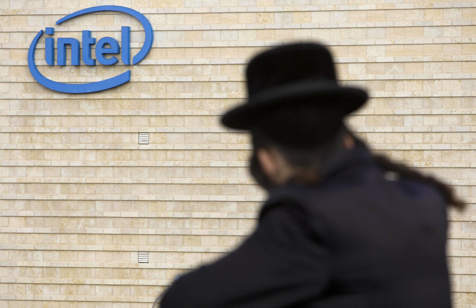 FILE - In this Nov. 14, 2009 file photo, an ultra-Orthodox Jewish man is seen next to Intel's office building in Jerusalem. Intel said Monday, May 4, 2020, that it has purchased Israeli urban mobility startup Moovit for $900 million. The California-based chipmaker said the purchase buttresses its plan to become a "complete mobility provider. (AP Photo/Bernat Armangue, File)