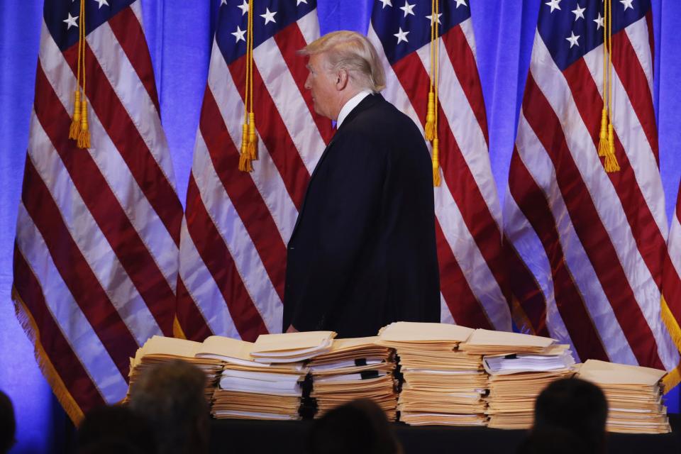 Trump walks past a pile of papers during his first news conference as president-elect. (Photos: Lucas Jackson/Reuters)