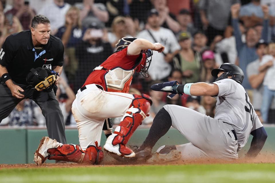 New York Yankees' Aaron Judge scores against Boston Red Sox catcher Connor Wong during the ninth inning of a baseball game, Friday, June 14, 2024, in Boston. (AP Photo/Michael Dwyer)