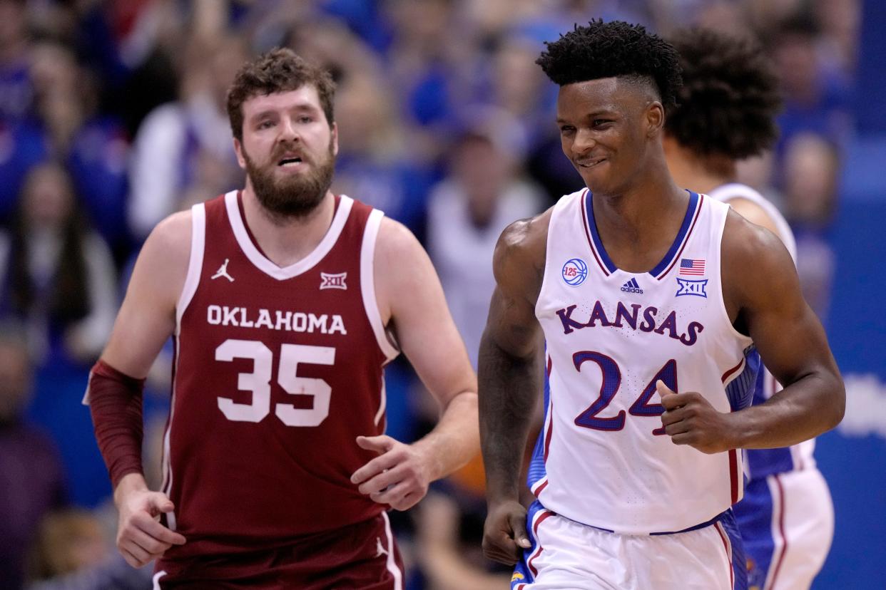 Kansas forward K.J. Adams Jr. (24) smiles as he runs down court ahead of Oklahoma forward Tanner Groves (35) after making a basket during the second half of an NCAA college basketball game Tuesday, Jan. 10, 2023, in Lawrence, Kan. Kansas won 79-75.