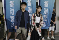 Pro-democracy activists Joshua Wong, left, and Agnes Chow speak to media outside a district court upon arrival for a hearing in Hong Kong, Friday, Nov. 8, 2019. Wong and Chow were charged with inciting people to join a protest in June and are currently on bail. (AP Photo/Dita Alangkara)