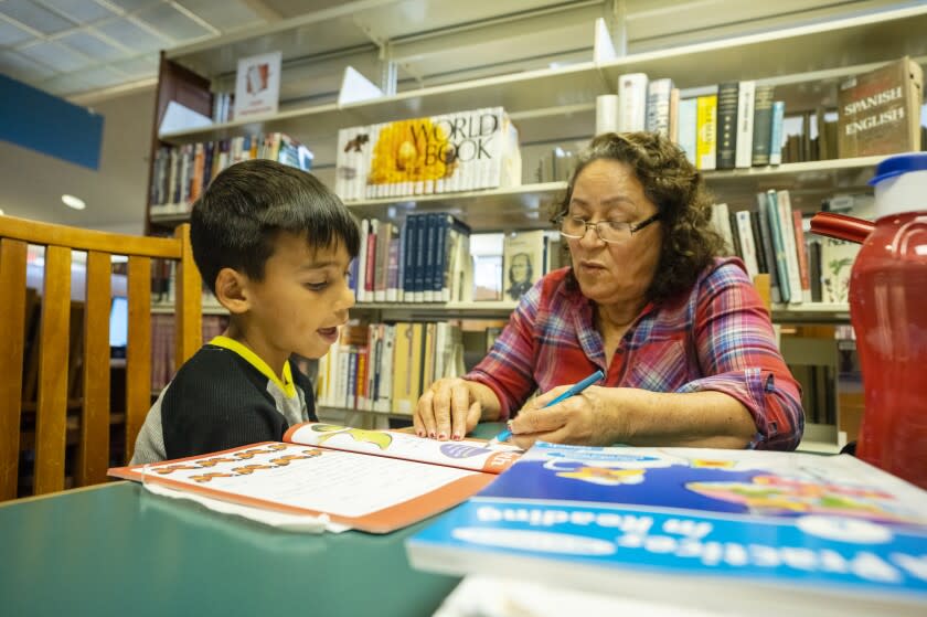 McFARLAND CA APRIL 22, 2022 - Nicolas Maldonado, 7, is tutored by Bertha Cuate at the Clara M. Jackson Branch, Kern County Library in McFarland. McFarland, a small Kern County town of 14,000, is facing the possible closure of its only public library so the McFarland police department would occupy the building to have more space. The McFarland Police Department currently shares a building with the city hall. The community has expressed opposition to the closure of McFarland's only public library. (Tomas Ovalle / For The Times)