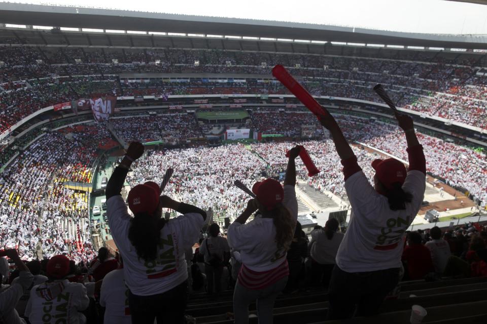 Supporters of Enrique Pena Nieto, presidential candidate of the opposition Institutional Revolutionary Party, PRI, cheer during a campaign rally at Azteca stadium in Mexico City, Sunday, June 24, 2012. General elections in Mexico are scheduled for Sunday, July 1. (AP Photo/Esteban Felix)