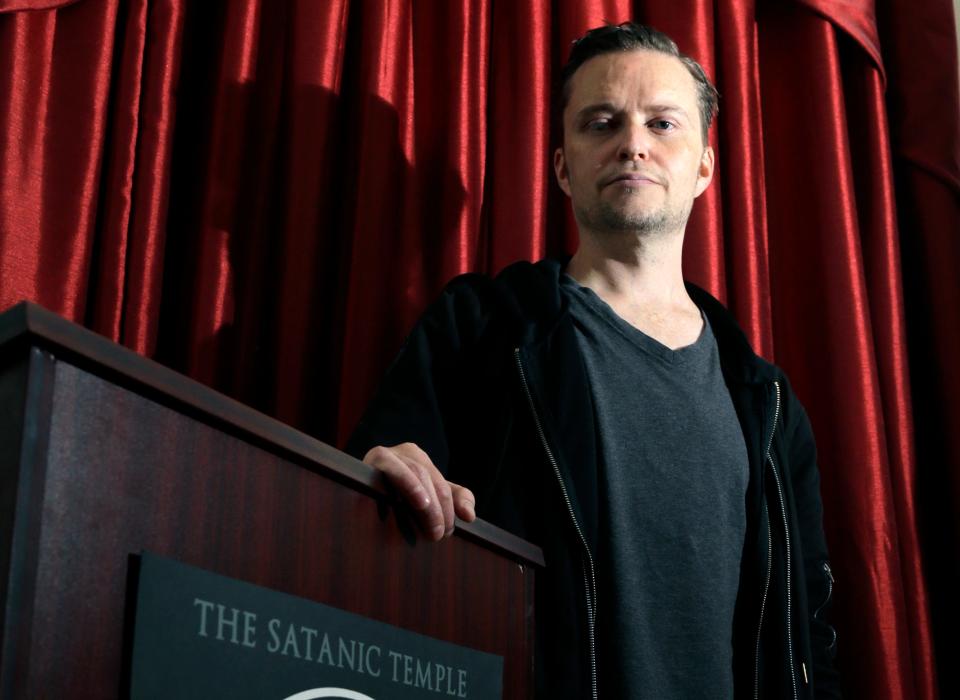 In this Oct. 24, 2016 photo, Lucien Greaves stands inside the recently opened international headquarters of the Satanic Temple in Salem, Mass. The Satanic Temple is waging religious battles along a variety of fronts nationwide, and its co-founder says it's just getting started. Greaves says the temple hopes to ensure Satanists "have a place in the world" and that "evangelical theocrats" don't monopolize the religious freedom debate. (AP Photo/Elise Amendola)