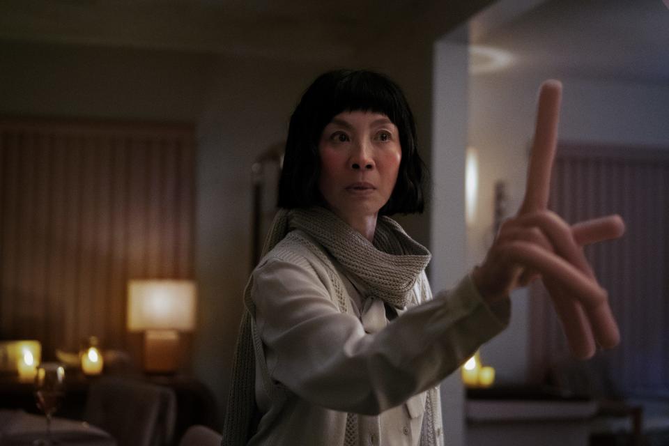 Evelyn (Michelle Yeoh) lives out several different realities, including one where she has hot dog fingers, in the sci-fi comedy "Everything Everywhere All at Once."