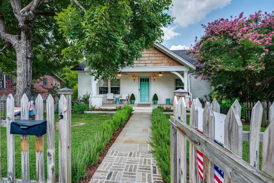 With a picket fence and brick pathway, the front of 1715 Holly St. is charming and inviting.