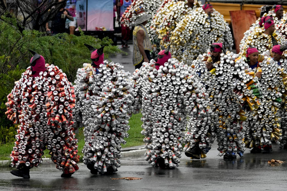 Revelers wearing costumes made from beer and soda cans take part in the 'Bloco da Latinha' street party Carnival parade in Madre de Deus, Brazil, Sunday, Feb. 11, 2024. (AP Photo/Eraldo Peres)