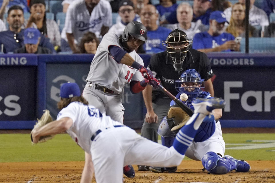 Minnesota Twins' Jorge Polanco, second from left, hits a three-run home run as Los Angeles Dodgers starting pitcher Ryan Pepiot, left, watches along with Los Angeles Dodgers catcher Will Smith, right, and home plate umpire Nestor Ceja during the third inning of a baseball game Wednesday, Aug. 10, 2022, in Los Angeles. (AP Photo/Mark J. Terrill)