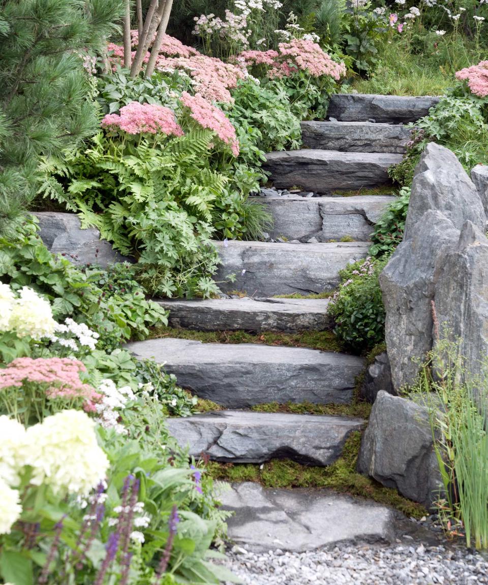 <p> Take a cue from the great outdoors and try landscaping with boulders in your garden. Sculptural and striking, they almost always look impressive, and look even better when surrounded by plants, such as the ferns and sedum seen here. </p> <p> Build your steps out of flat-topped rocks to extend the theme. To really create that organic look, avoid using straight lines, and encourage moss to grow in the nooks and crannies between each. It's a lovely solution for steps set away from the main pathways of your garden – perhaps leading to a hidden summer house or hammock. </p>