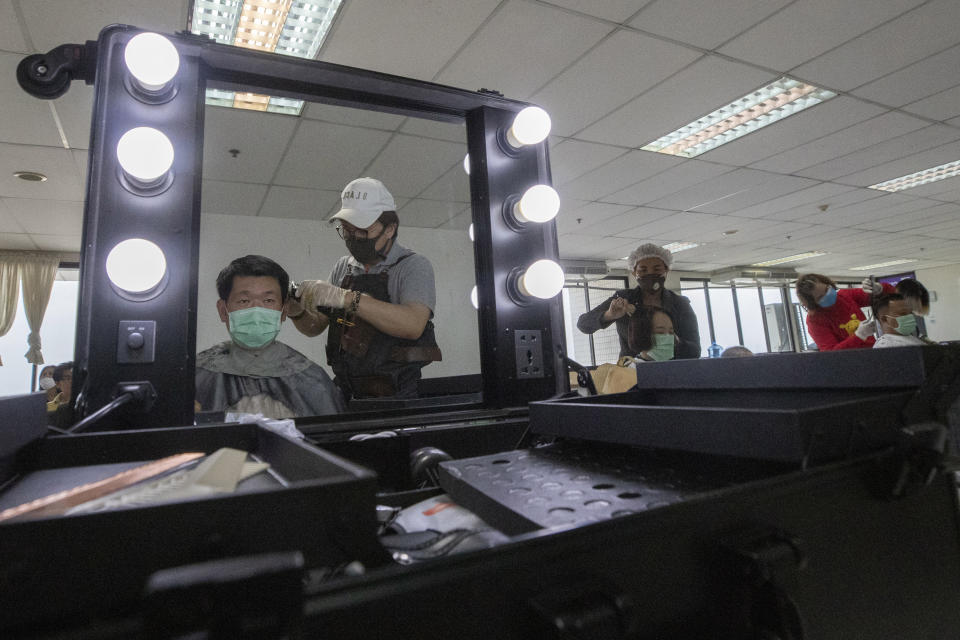 In this Tuesday, April 28, 2020, photo, volunteers of hairdressers give haircuts to medical workers treating COVID-19 patients at Bangkok Metropolitan Administration General Hospital in Bangkok, Thailand. Hairstylest Pornsupa Hattayong, 43, is boosting the morale of frontline medical workers by dispensing free haircuts at Bangkok hospitals since Thailand’s hair salons have been closed for more than a month, to help stop the spread of the coronavirus. (AP Photo/Sakchai Lalit)