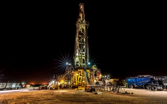 An illuminated drilling rig at night