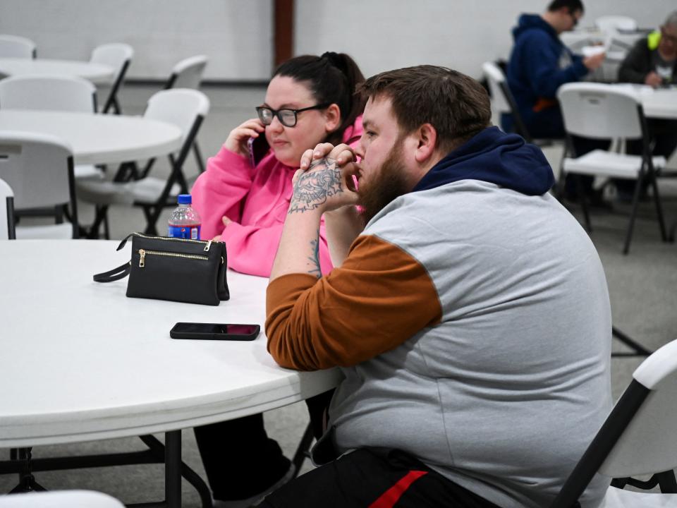 Brittany Vargo and Marcus Turner sit at an assistance center, following a train derailment that forced people to evacuate from their homes, in New Waterford, Ohio, U.S., February 6, 2023.