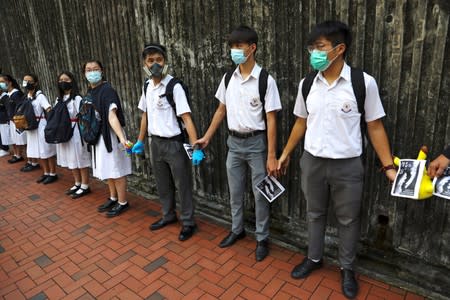 Secondary school students hold hands as they form a human chain in Hong Kong