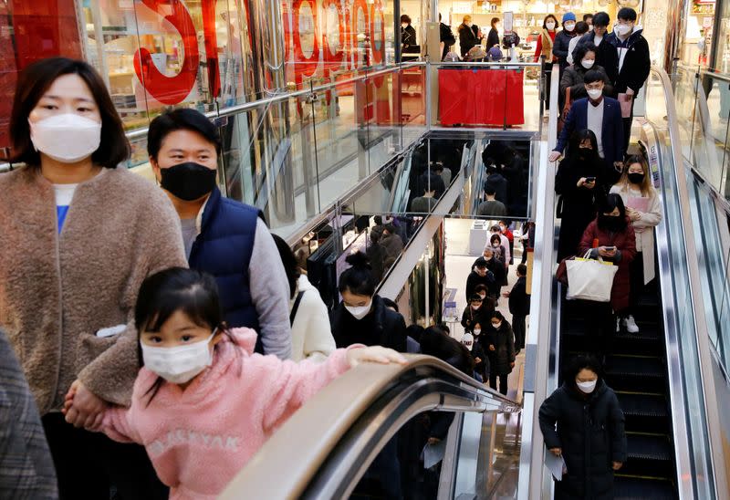 People wearing masks to prevent contracting the coronavirus take the elevator to buy masks at a department store in Seoul