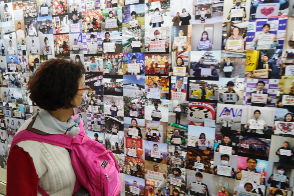 一位民眾經過展示日本東北民眾感謝台灣的照片牆。   圖：張良一/攝
