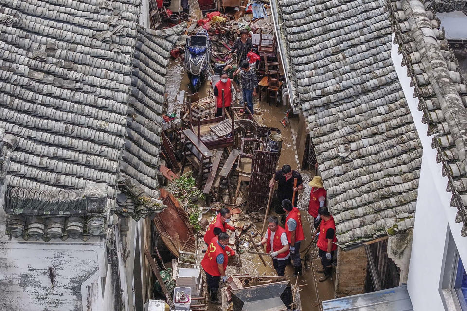 In this photo released by Xinhua News Agency, workers clean a street flooded after heavy rainfall in Huicheng Town of Shexian County, central China's Anhui Province, Friday, June 21, 2024. China's National Meteorological Center issued a warning for more extreme weather across a swath of provinces in the south on Saturday, extending a warning from Friday, and for a few areas in the north. Henan and Anhui provinces in central China, as well as Jiangsu province on the coast and the southern province of Guizhou, all are expecting hail and strong thunderstorms, according to the forecast. (Fang Junyao/Xinhua via AP)