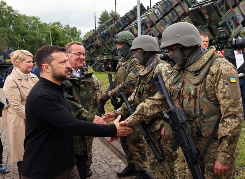 German Minister of Defense Boris Pistorius (C) Ukrainian President Volodymyr Zelensky and Manuela Schwesig (L), Minister President of Mecklenburg-Western Pomerania, welcome German and Ukrainian soldiers during their visit to a military training area to learn about the training of Ukrainian soldiers on the "Patriot" air defence missile system. Jens Büttner/dpa