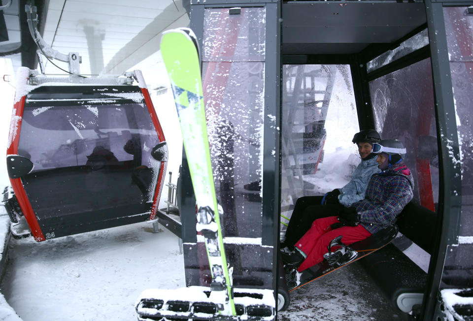 Skiers ride a lift line on Mount Jahorina, 30 kilometers south of the Bosnian capital of Sarajevo, Tuesday, Dec. 7, 2021. As most of Europe reintroduces measures to help curb the spread of the omicron variant, Bosnia, to the delight of its winter tourism industry, still maintains a relatively laissez-fair approach to the soaring COVID-19 infection numbers across the continent. (AP Photo/Marjan Vucetic)