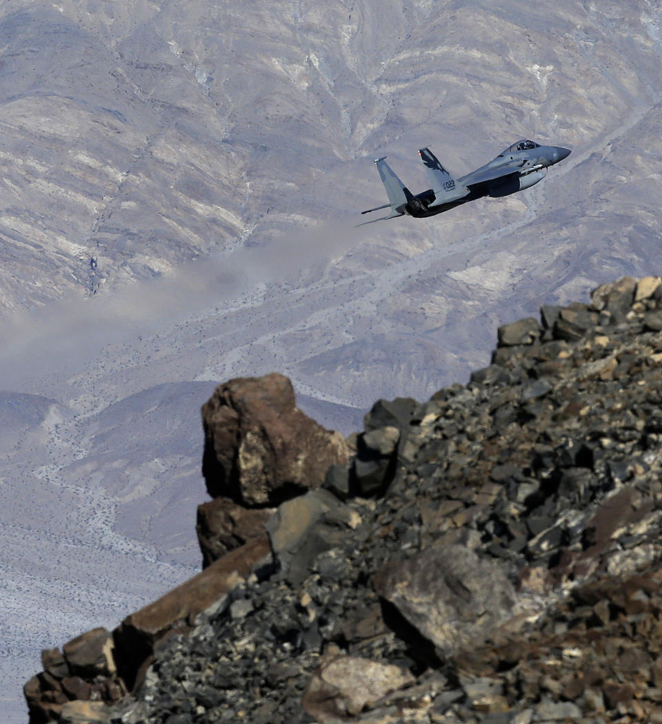 In this Feb. 28, 2017, photo, an F-15C Eagle from the California Air National Guard, 144th Fighter Wing, flies out of the nicknamed Star Wars Canyon over Death Valley National Park, Calif. Military jets roaring over national parks have long drawn complaints from hikers and campers. But in California's Death Valley, the low-flying combat aircraft skillfully zipping between the craggy landscape has become a popular attraction in the 3.3 million acre park in the Mojave Desert, 260 miles east of Los Angeles. (AP Photo/Ben Margot)