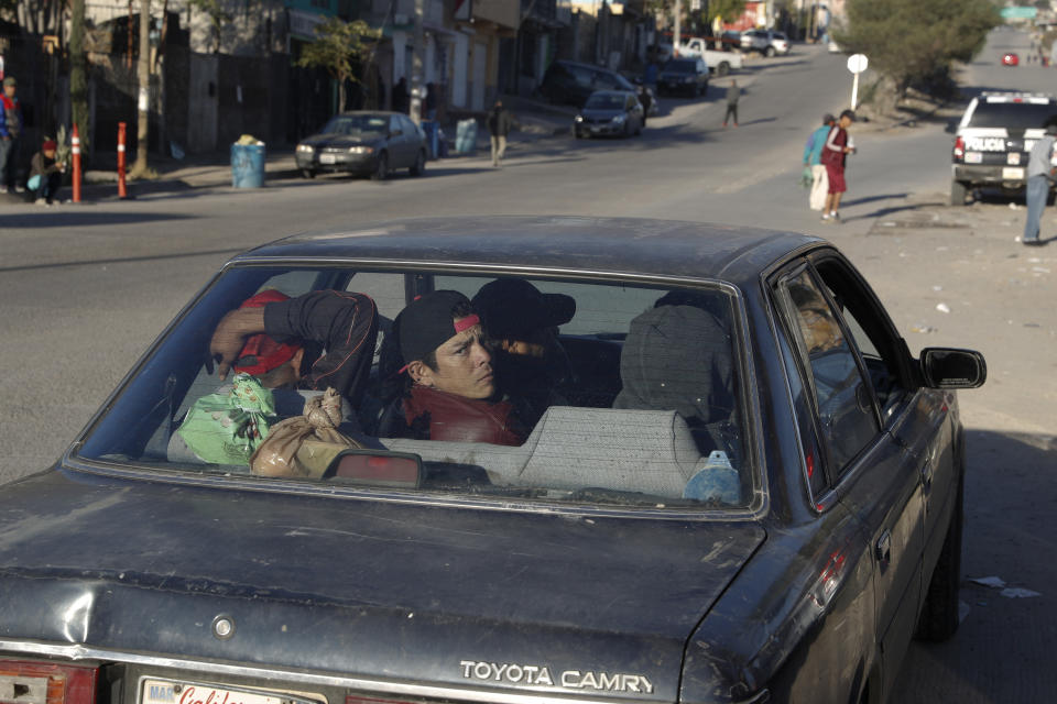 In this Dec. 5, 2018 photo, Honduran migrant Jose Elino, 23, looks back as he and other migrants are picked up by a construction business owner for a day of manual labor, outside a former concert venue serving as a shelter in Tijuana, Mexico. Facing the possibility of a months-long wait in Tijuana before even having an opportunity to request asylum in the United States, members of the migrant caravans that have arrived in Tijuana are looking for work. (AP Photo/Rebecca Blackwell)