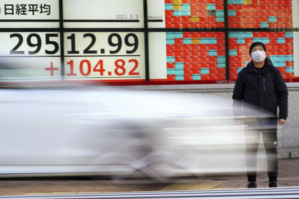 A man wearing a protective mask stands in front of an electronic stock board showing Japan's Nikkei 225 index at a securities firm Wednesday, March 3, 2021, in Tokyo. Stocks advanced in Asia on Wednesday after a wobbly day on Wall Street, when the S&P 500 gave back most of its gains from a day earlier. (AP Photo/Eugene Hoshiko)