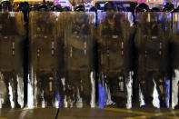 Riot police in protective gear form up during a confrontation with protesters in Hong Kong on Saturday, Aug. 3, 2019. Hong Kong protesters removed a Chinese national flag from its pole and flung it into the city's iconic Victoria Harbour on Saturday, and police later fired tear gas at demonstrators after some of them vandalized a police station. (AP Photo/Vincent Thian)