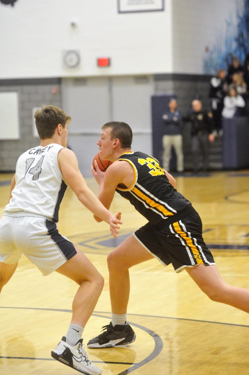 Colonel Crawford's Payne DeGray looks for an open teammate with Carey's Austin Niederkohr closing in.