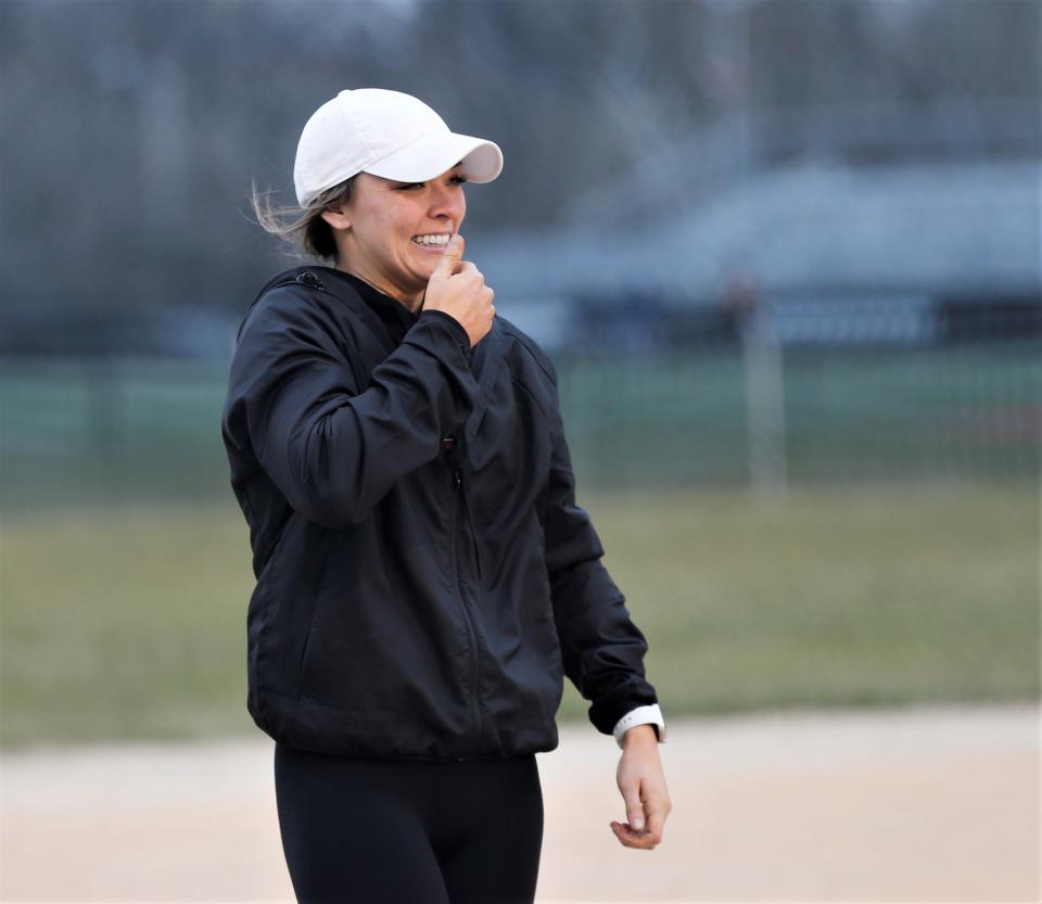 Richmond head coach Alexis Cox smiles at her batter while coaching from third base during a scrimmage against Adams Central March 21, 2023.